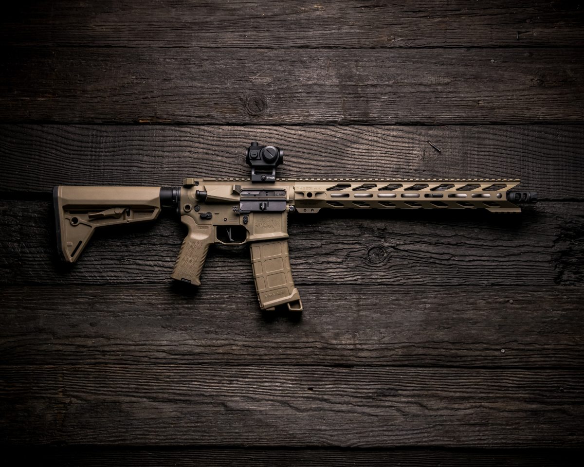 A black and brown AR-15 laying on a table