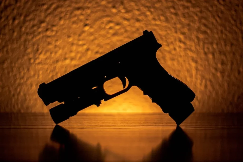 Silhouette of a pistol with a flashlight attachment
